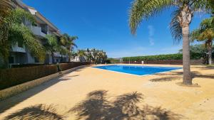 a swimming pool with a palm tree next to a building at Quinta do Pinheiro Premium by Sunny Deluxe in Olhos de Água
