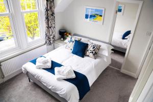 a bedroom with a bed with blue and white pillows at Kingsway Guesthouse - A selection of Single, Double and Family Rooms in a Central Location in Scarborough