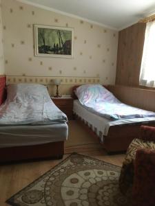 1 dormitorio con 2 camas y alfombra en Kilátó úti Vendégház, en Mátrafüred