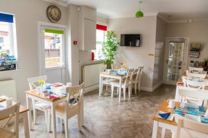 a dining room with tables and chairs and a clock on the wall at Kingsway Guesthouse - A selection of Single, Double and Family Rooms in a Central Location in Scarborough