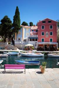a bunch of boats in the water next to a building at Apartments VESNA (63) in Veli Lošinj