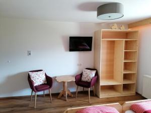 a living room with two chairs and a table at Zachhof in Ellbögen