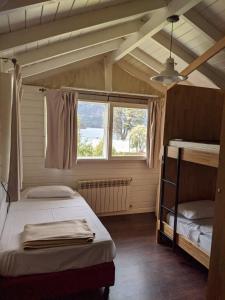 1 dormitorio con 2 literas y ventana en INDÓMITO HOSTEL en San Carlos de Bariloche