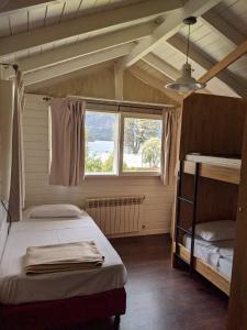 a bedroom with two bunk beds and a window at INDÓMITO HOSTEL in San Carlos de Bariloche