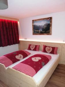 a bedroom with a large bed with red pillows at Zachhof in Ellbögen