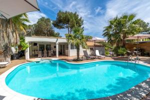 - une grande piscine dans une cour bordée de palmiers dans l'établissement La Villa de l'Olivier, au Cap d'Agde
