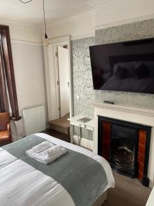 a bedroom with a fireplace and a bed at The Lady Elizabeth Hotel in Sudbury