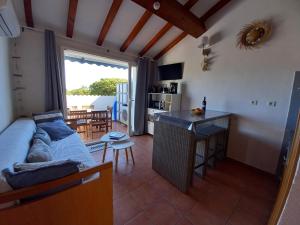 ein Wohnzimmer mit Couch und Tisch und eine Küche in der Unterkunft Appartement avec piscine vue mer et montagne in San-Nicolao