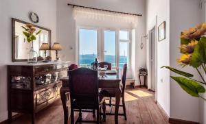 a dining room with a table and chairs and a window at Antigoni's Bay House in Adamantas