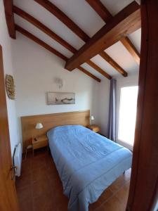 ein Schlafzimmer mit einem blauen Bett und einem Fenster in der Unterkunft Appartement avec piscine vue mer et montagne in San-Nicolao
