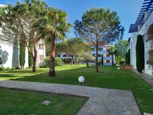 ein Park mit Palmen und ein Gebäude in der Unterkunft Appartement avec piscine vue mer et montagne in San-Nicolao