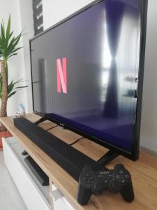 TV y 2 controladores de videojuegos sobre una mesa en Marlen’s Apartment en Bucarest