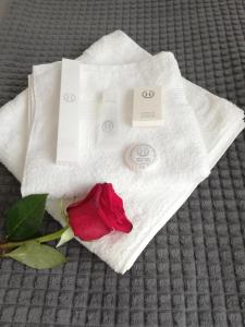 a red rose sitting on top of a white towel at Marlen’s Apartment in Bucharest