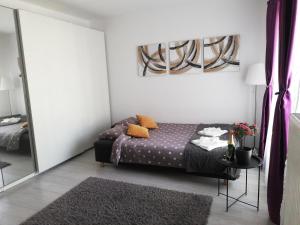 a bedroom with a bed and a table and a mirror at Marlen’s Apartment in Bucharest