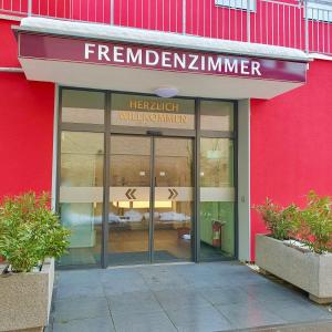 a red building with a sign on the front of a store at Hotel Da Sabino in Singen