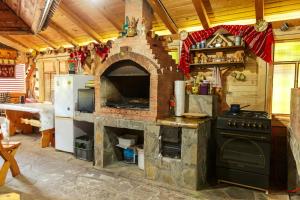 a kitchen with a brick oven and a refrigerator at Casa dintre munti Karina in Nehoiu