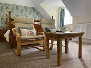 a living room with two chairs and a table at Lancasters Cottage in Horsham