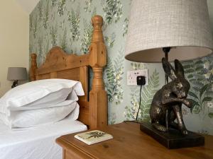 a lamp sitting on a table next to a bed at Lancasters Cottage in Horsham