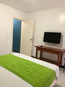 a bedroom with a bed and a desk with a computer at Eco Paradise Sunset Beach in Cumbuco