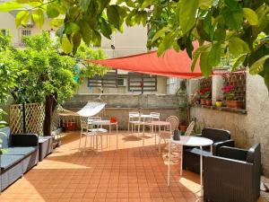d'une terrasse avec des tables et des chaises sous un parasol rouge. dans l'établissement Relais Villa Fiorelli, à Rome