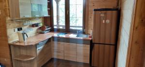 a kitchen with wooden cabinets and a sink and a refrigerator at Kazkova Sadyba in Slavske