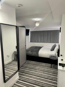 een hotelkamer met een bed en een spiegel bij Wisteria Studio in Londen