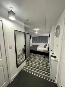 Wisteria Studio في لندن: غرفة نوم بسرير ومرآة كبيرة