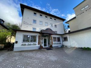 a large white building with a courtyard in front of it at Pension Steinbacher in Bad Gastein