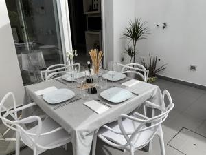 a dining room table with white chairs and a white table cloth at Villa Luminosa in Torre del Lago Puccini