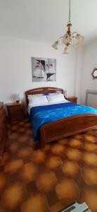 una camera da letto con letto con lenzuola blu e soffitto di Locanda dei miracoli a Pizzoli