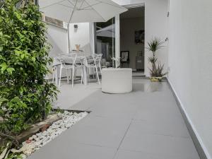 a patio with an umbrella and a table and chairs at Villa Luminosa in Torre del Lago Puccini