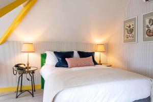 a bedroom with a large white bed with two lamps at The Canford in Poole