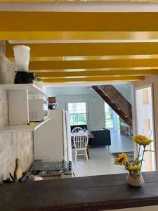 a kitchen with yellow ceilings and a living room at Casa com 3 suítes - À 150m da praia de Geribá in Búzios