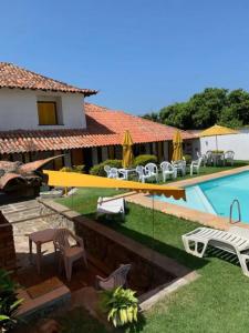 a villa with a swimming pool and patio furniture at Casa com 3 suítes - À 150m da praia de Geribá in Búzios