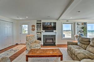 a living room with a couch and a fireplace at Sunny Beach House Getaway - Steps From Water! in Mattapoisett