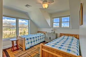 two beds in a room with two windows at Sunny Beach House Getaway - Steps From Water! in Mattapoisett
