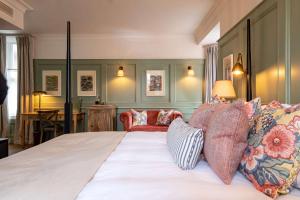 a bedroom with a large bed with colorful pillows at The Canford in Poole