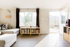ein Wohnzimmer mit einem Sofa und einem Bücherregal mit Büchern in der Unterkunft @ Marbella Lane - 10 Acres Oasis Desert Retreat! in Joshua Tree
