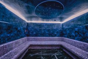 um quarto azul com uma banheira com um espelho em Meta Business Hotel By King David em Tbilisi