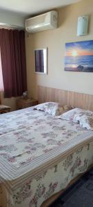a bedroom with a large bed with a floral bedspread at Guest House Tony in Nesebar