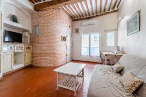 a living room with a couch and a brick wall at L'atypique par Dodo-a-Cassis in Cassis