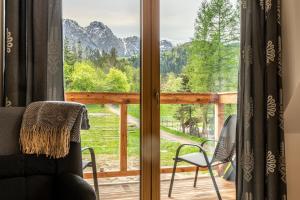 a room with a window with a view of the mountains at Biały Miś Apartamenty Art & Design in Zakopane