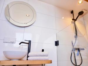 ein Bad mit einem Waschbecken und einem Wandspiegel in der Unterkunft Studio Torenzicht in Westkapelle