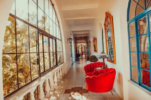 a hallway with two red chairs and windows at Hotel Gramado Palace in Gramado