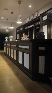 a woman sitting at a counter in a store at New Era Hotel Old Town - Covered pay parking within 10 minutes walk in Bucharest