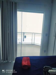 a bedroom with a bed and a large window at Casa-2 Condomínio Elza em Arraial do Cabo in Arraial do Cabo +11 photos