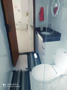 a small bathroom with a toilet and a sink at Casa-2 Condomínio Elza em Arraial do Cabo in Arraial do Cabo +11 photos