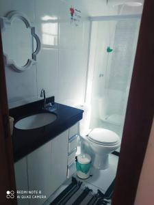 a small bathroom with a toilet and a sink at Casa-2 Condomínio Elza em Arraial do Cabo in Arraial do Cabo