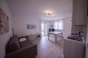 uma sala de estar com um sofá e uma cozinha em Paradise Garden & View em Tremosine Sul Garda