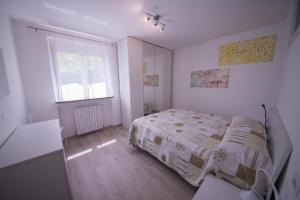 een witte slaapkamer met een bed en een raam bij Paradise Garden & View in Tremosine Sul Garda